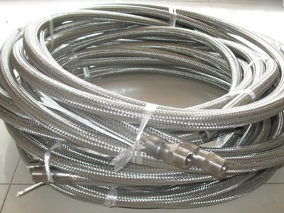 There are several metal hose rolls stacked together, all of them have metal connectors.